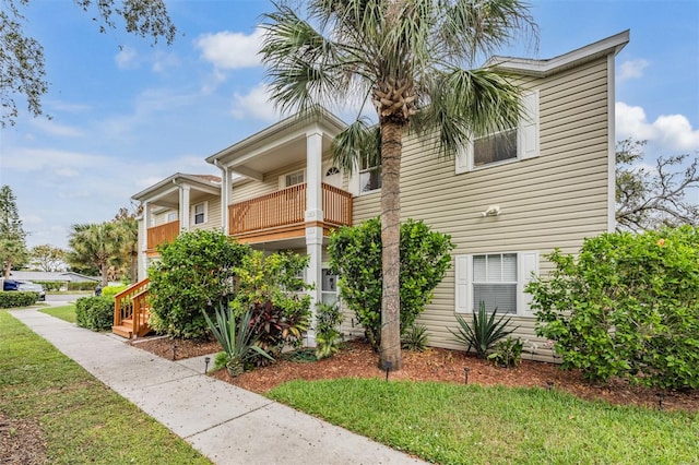 view of front of home with a balcony and a front lawn