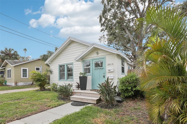 bungalow-style house featuring a front lawn