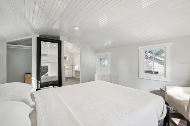 bedroom featuring vaulted ceiling and ensuite bath