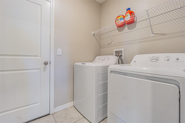 laundry room featuring washing machine and dryer and light tile patterned floors