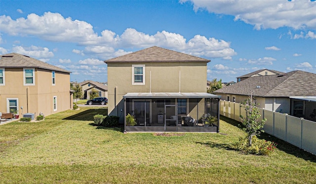 back of house with a yard and a sunroom