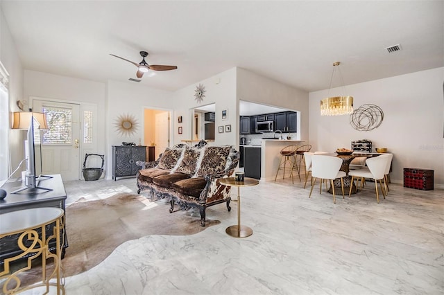 living room with ceiling fan with notable chandelier