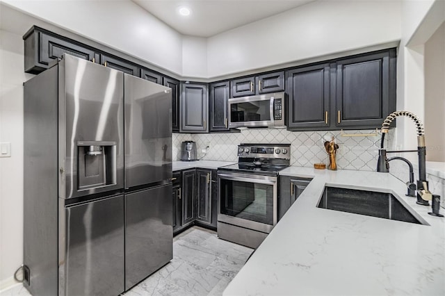 kitchen featuring light stone countertops, sink, appliances with stainless steel finishes, and tasteful backsplash