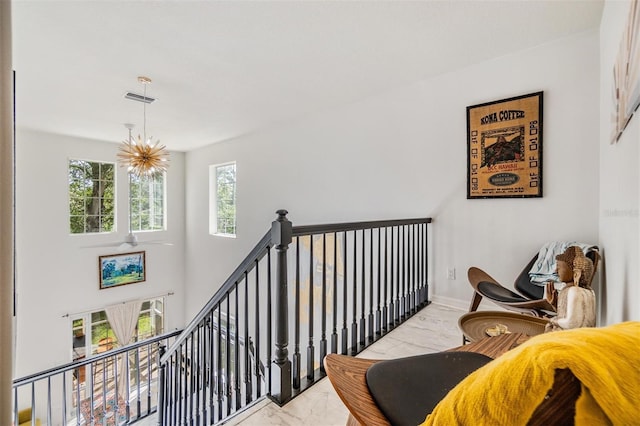 staircase featuring a wealth of natural light and a chandelier