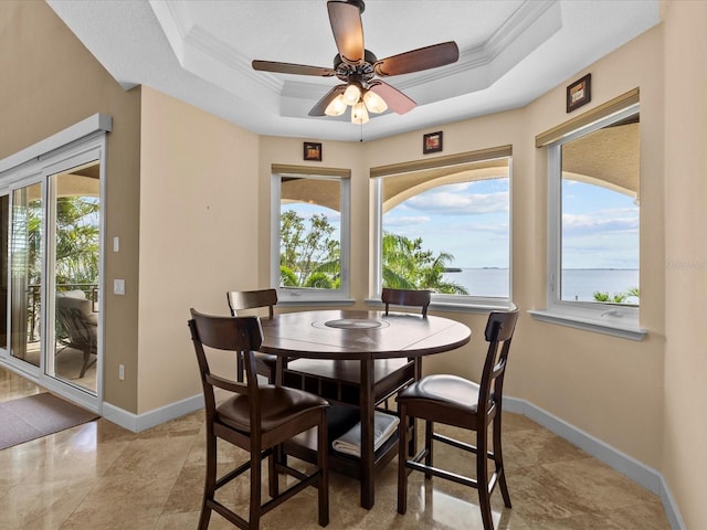 dining area with a water view, a wealth of natural light, and ornamental molding