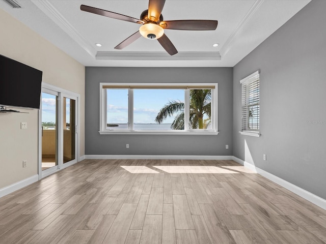 interior space featuring ceiling fan, a raised ceiling, light wood-type flooring, and ornamental molding