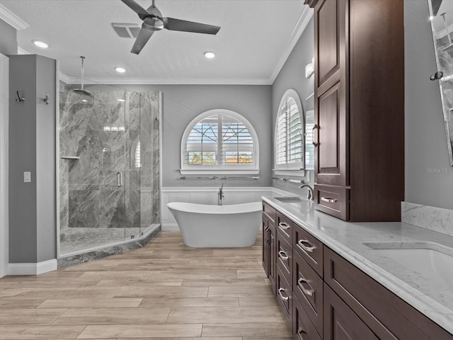 bathroom featuring shower with separate bathtub, vanity, ornamental molding, and hardwood / wood-style floors