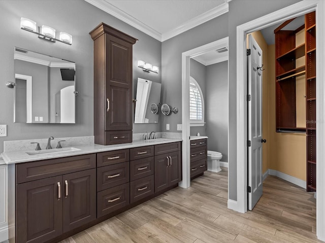 bathroom with toilet, hardwood / wood-style floors, vanity, and ornamental molding