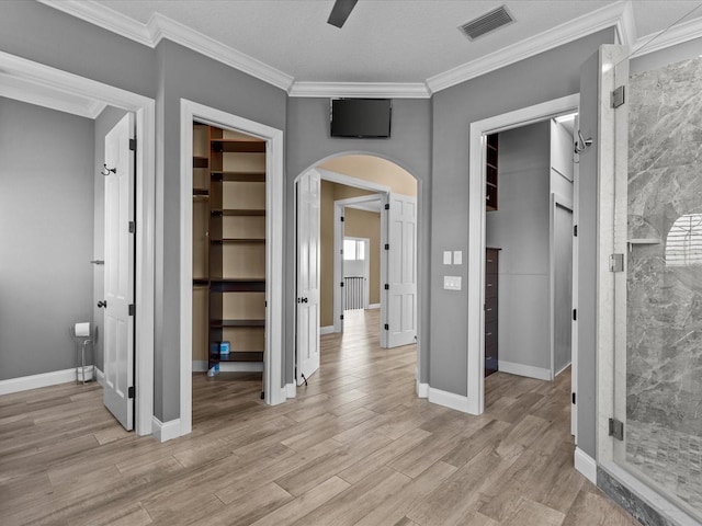 hall with light hardwood / wood-style flooring and ornamental molding