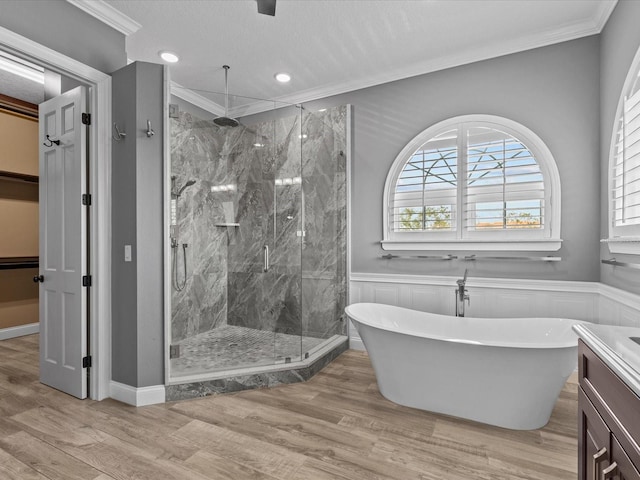 bathroom featuring a textured ceiling, vanity, crown molding, hardwood / wood-style flooring, and independent shower and bath