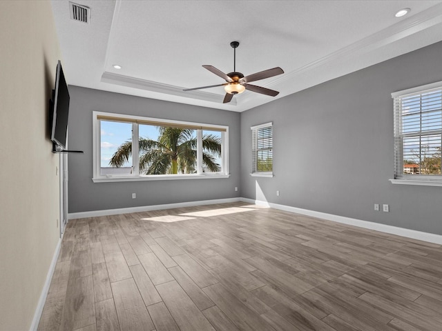 empty room featuring a wealth of natural light, light hardwood / wood-style flooring, and ceiling fan