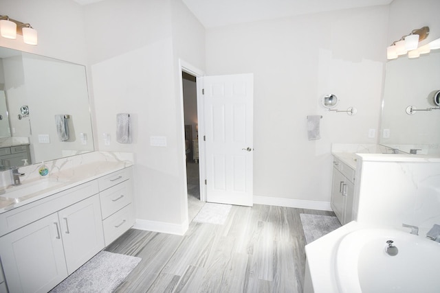 bathroom with hardwood / wood-style floors, vanity, and a bathing tub