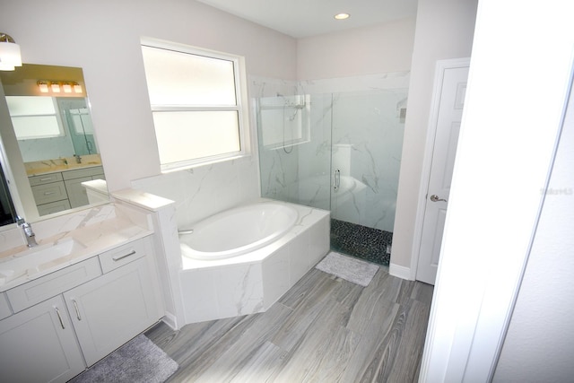 bathroom featuring shower with separate bathtub, vanity, and hardwood / wood-style floors