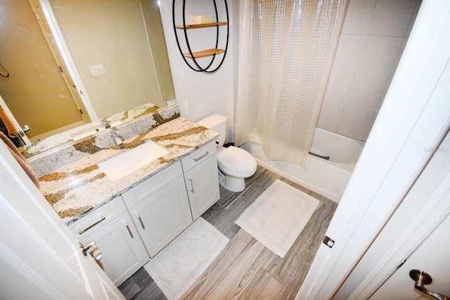 full bathroom featuring hardwood / wood-style floors, shower / bath combo with shower curtain, vanity, and toilet