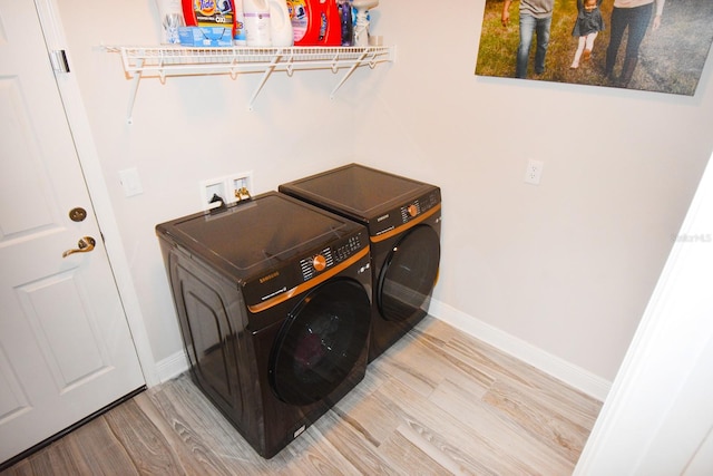 laundry area featuring light hardwood / wood-style flooring and washer and clothes dryer