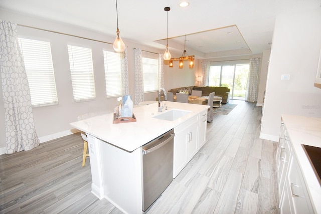 kitchen with white cabinets, sink, a kitchen island with sink, stainless steel dishwasher, and light hardwood / wood-style flooring