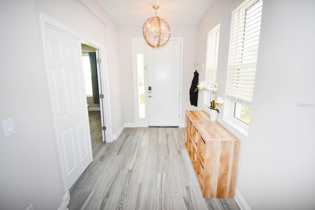 foyer featuring a chandelier, light wood-type flooring, and a wealth of natural light