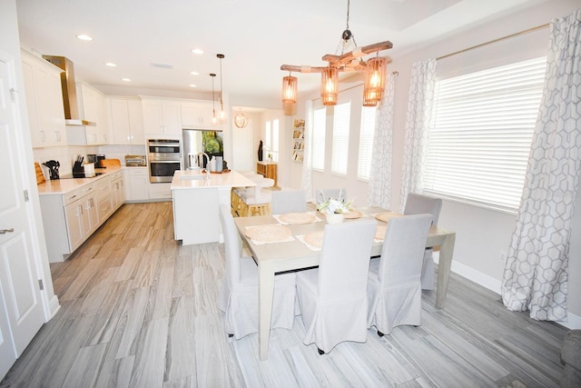 dining room featuring plenty of natural light, a chandelier, sink, and light hardwood / wood-style flooring