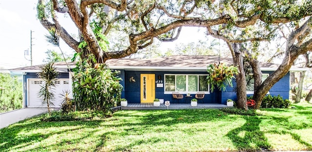130 63rd St S, Saint Petersburg, FL 33707 - single story home featuring a front yard, covered porch, a garage, and concrete driveway