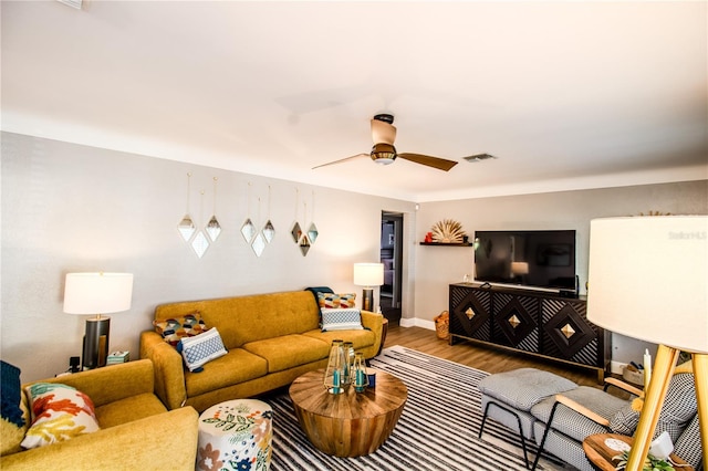 living room featuring wood-type flooring and ceiling fan