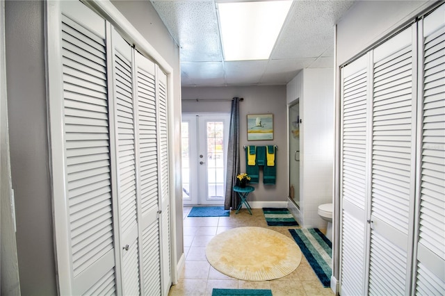 hallway with french doors and light tile patterned floors