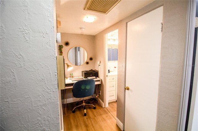 home office with light hardwood / wood-style floors