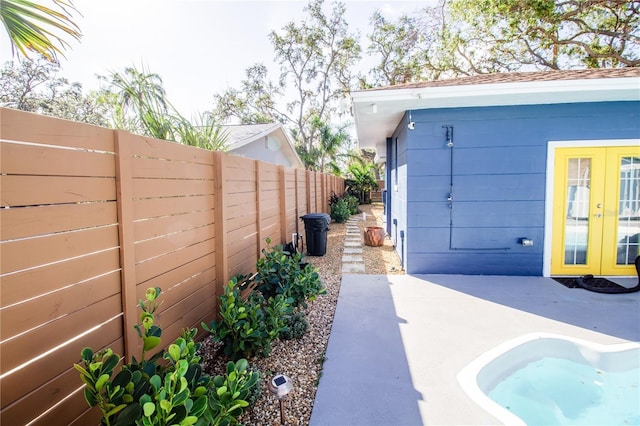 130 63rd St S, Saint Petersburg, FL 33707 - view of patio / terrace featuring french doors and a fenced backyard