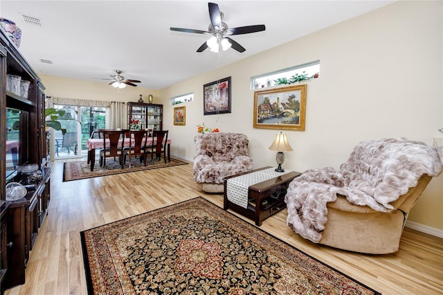 living room with ceiling fan and light hardwood / wood-style flooring