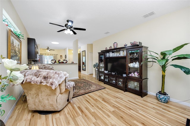 living room with light hardwood / wood-style floors and ceiling fan