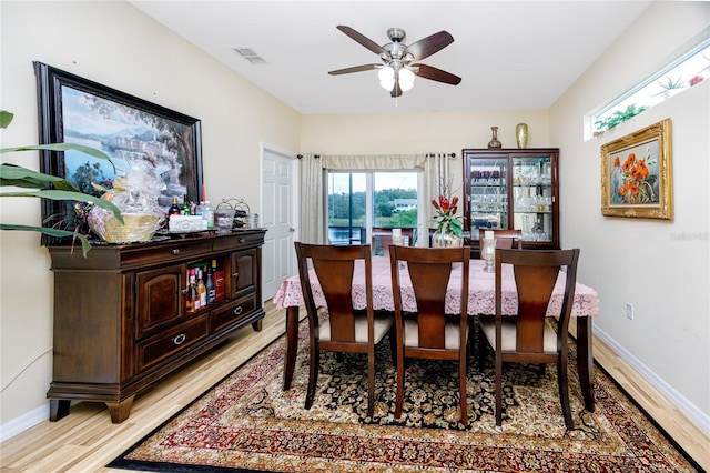 dining space with ceiling fan and light wood-type flooring