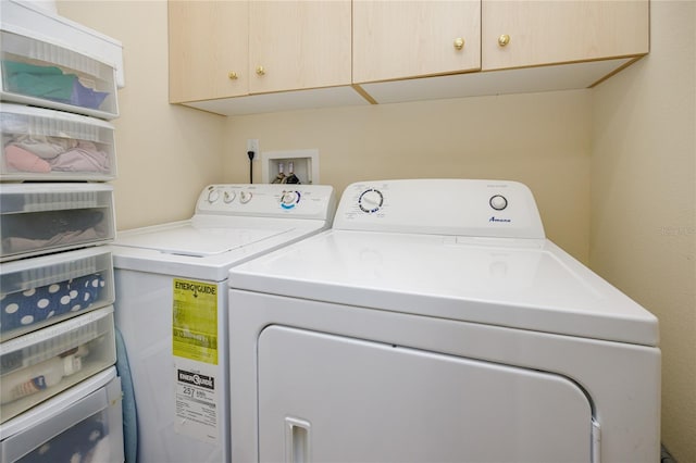 laundry room featuring cabinets and washer and clothes dryer