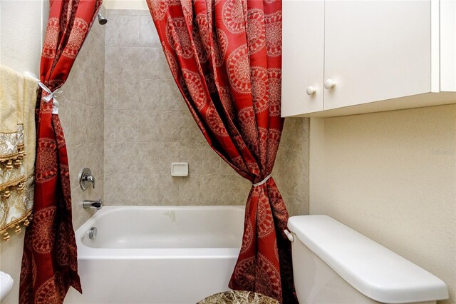 bathroom featuring shower / tub combo with curtain and toilet