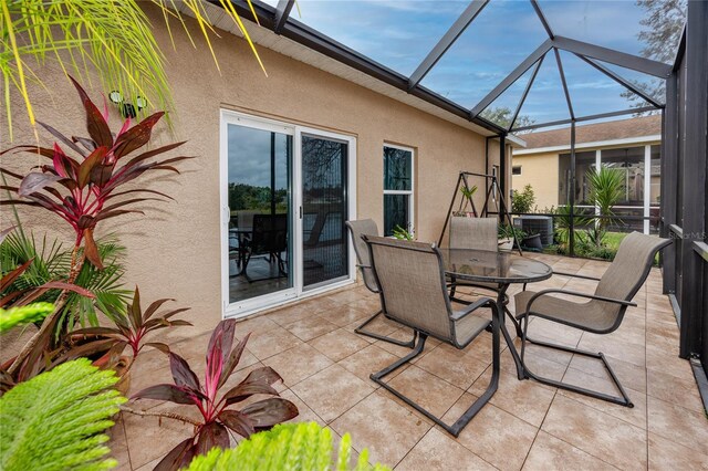 view of patio featuring central AC and glass enclosure