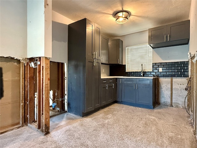 kitchen featuring light carpet, a textured ceiling, gray cabinets, and sink