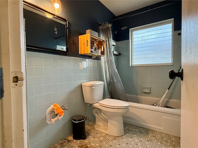 bathroom featuring tile patterned floors, shower / bath combo with shower curtain, tile walls, and toilet