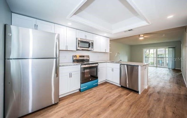 kitchen featuring white cabinetry, appliances with stainless steel finishes, and kitchen peninsula