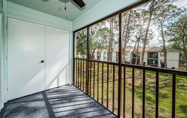 unfurnished sunroom with ceiling fan