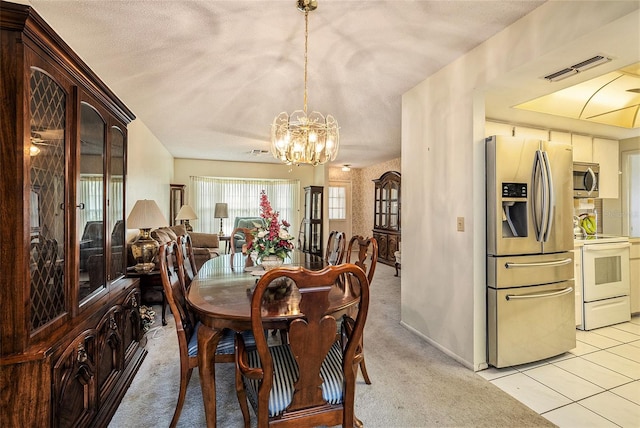 tiled dining space with a notable chandelier and a textured ceiling