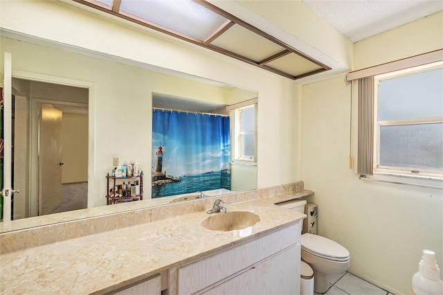 bathroom featuring tile patterned flooring, vanity, toilet, and a wealth of natural light