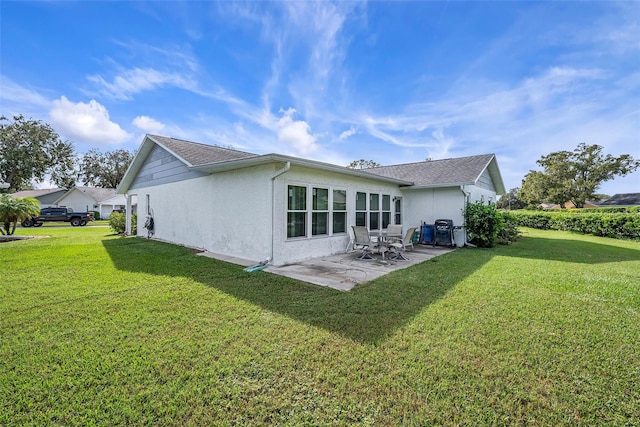 back of house featuring a lawn and a patio