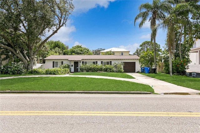 view of front of property with a garage and a front lawn