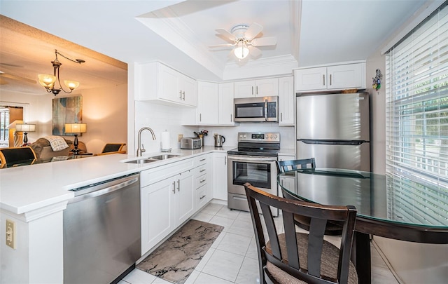 kitchen featuring kitchen peninsula, stainless steel appliances, white cabinetry, and sink