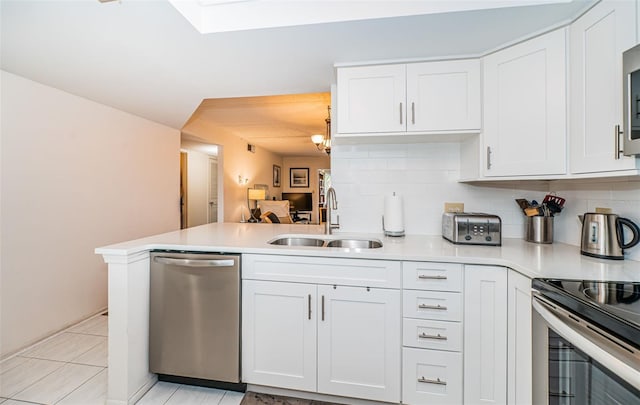 kitchen with white cabinets, sink, kitchen peninsula, and stainless steel appliances