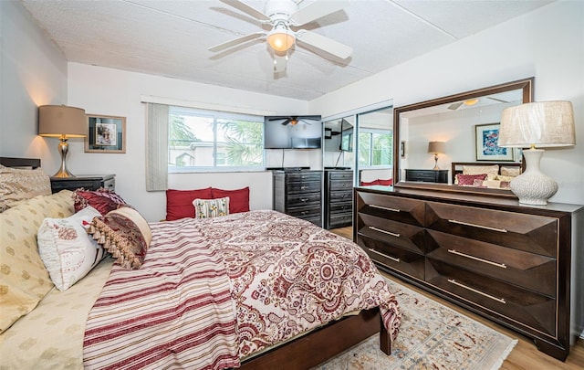 bedroom with a textured ceiling, light hardwood / wood-style floors, and ceiling fan