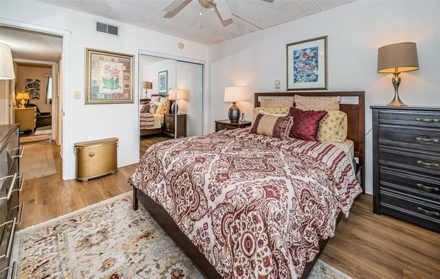 bedroom featuring dark hardwood / wood-style floors, ceiling fan, a textured ceiling, and a closet