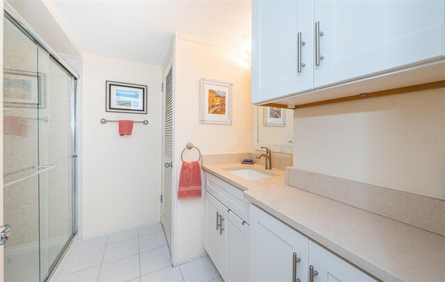 bathroom featuring vanity, tile patterned floors, and a shower with shower door