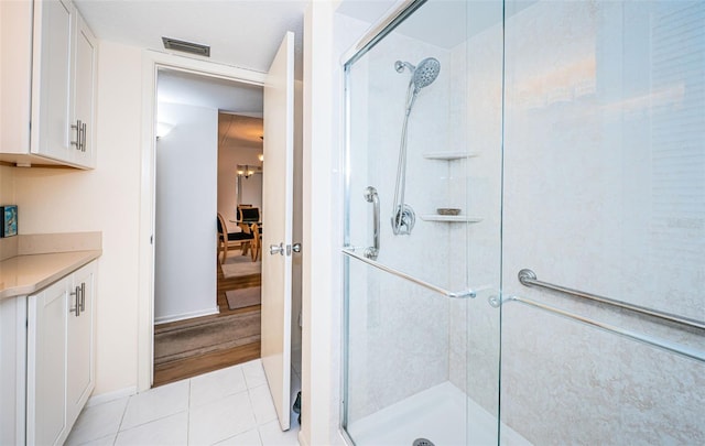 bathroom with tile patterned floors, vanity, and a shower with shower door