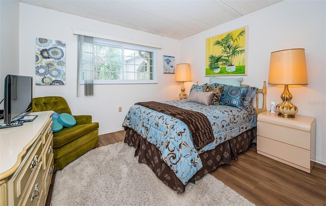 bedroom with dark hardwood / wood-style flooring