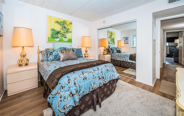 bedroom with dark hardwood / wood-style flooring and a closet