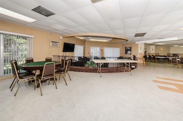 dining space featuring a paneled ceiling and an AC wall unit